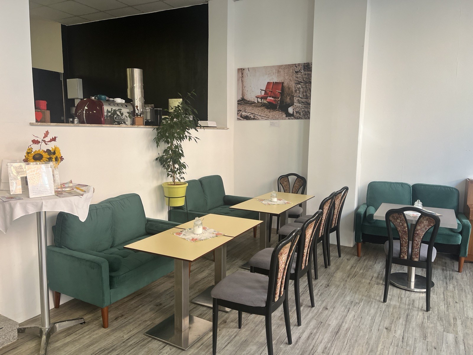 Gemütliche Sitzecke mit grünen Sofas im Café J3:16